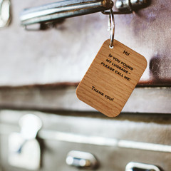 Wooden Luggage tag with the inscription on the handle of a vintage suitcase. Close up.