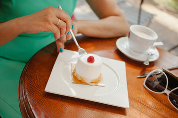 Woman in the cafe with a cup of coffee and dessert, soft focus. On table plate with breakfast. pleasant morning, the beginning of the working day