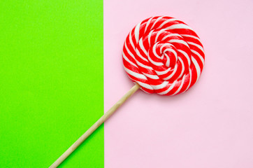 lollipop, a beautiful red and white striped lollipop on a green-pink background