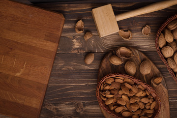 Fototapeta premium Flat lay of almonds in the wicker plates with other accessories on brown wooden background top view 10