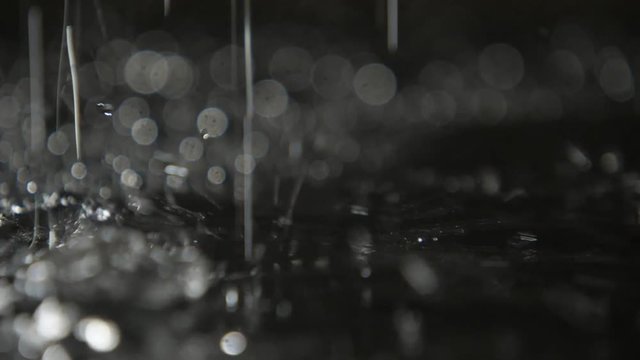 Fabulous dots of rainy water shining on a cave land with strange dots in slo-mo 