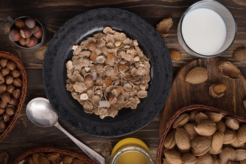 Flat lay of healthy breakfast with nuts and corn flakes on brown rustic background 2