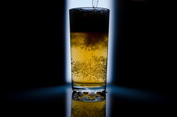 glass of beer on dark background,glass of cold beer on the table. object on a black background, а...