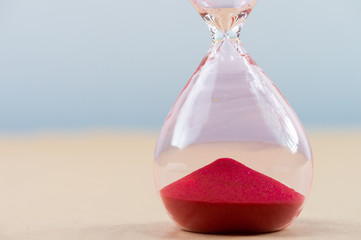 Hourglass with flowing sand on table. Time management
