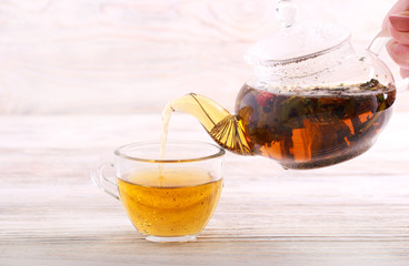Pouring hot herbal tea in a cup