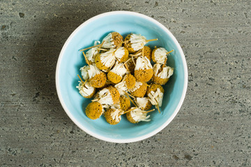 dried chamomiles on dark wooden table