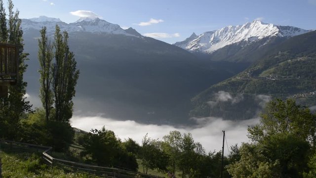 view above clouds on alpine mountains in park of the vanoise snowy peak