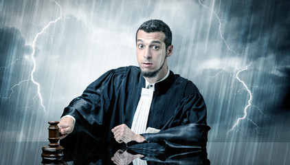 Fototapeta na wymiar Young handsome judge with stormy wallpaper 