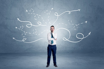 Elegant businessman choosing between directions with winding drawn arrows around 
