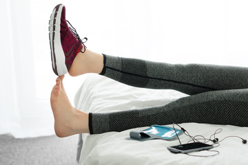 Woman's feet up on bed in home. Concept Relaxation after running.