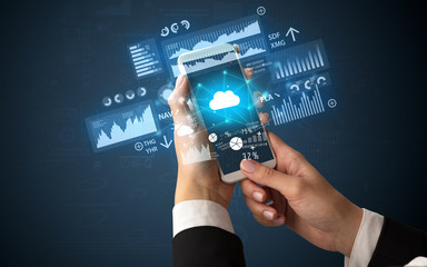 Female hand using smartphone with financial tracking concept illustrated by graphs and symbols