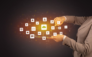 Female hand touching tablet with application icons above