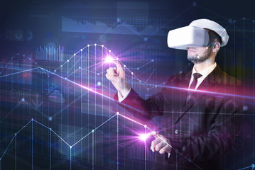 Businessman with virtual reality goggles organizing 3D graphs charts and financial variables
