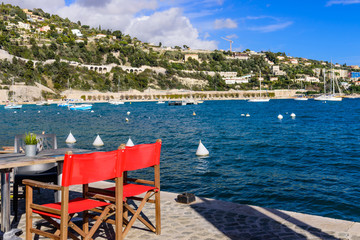 Fototapeta na wymiar Villefranche-sur-Mer old town. The scenic waterfront of the Mediterranean sea with street cafe, France