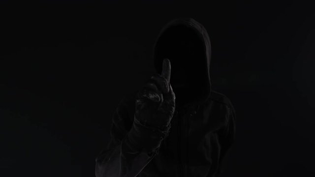 Darknet market concept with faceless hooded male person, low key footage with digital glitch effect