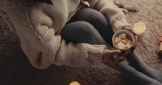 Cup Of Hot Chocolate With Marshmallow And Woman Legs In Cozy stockings in the morning