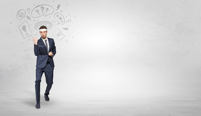 Young businessman in suit fighting with doodled symbols concept
