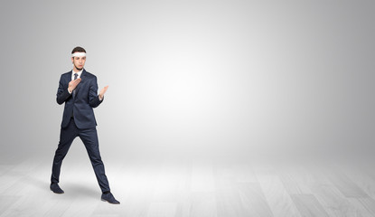 Young businessman in suit fighting in an empty space
