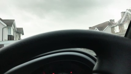 Low angle of a dirty car windshield being cleaned using the screenwash fluid and wipers.