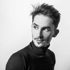 Handsome young elegant man in golf. Black-white studio photo.