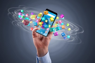 businessman holding a smartphone with icon cubes spinning around