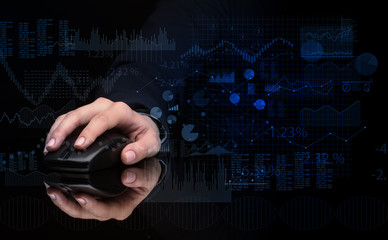 Hand using wireless mouse with financial concept on dark background
