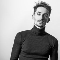 Handsome young elegant man in golf. Black-white studio photo.