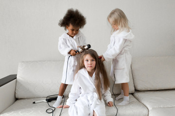 Hair care in children. Baby hairstyles. Girls 5-7 years old make each other hair on their heads.