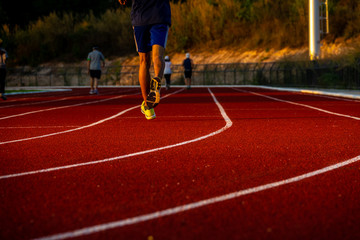 Red running track with runner's feet. Sport stadium for run.