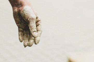 Raw clay in the hands of strong man. Selective focus