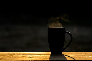 Fototapeta na wymiar Black hot coffee with morning light on wooden table