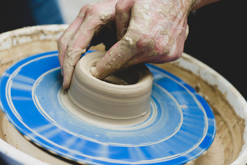 Street master class on modeling of clay on a potter's wheel In the pottery workshop