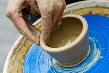 women's hands work with light clay on a rotating potter's wheel. Street master class on modeling of clay on a potter's wheel In the pottery workshop