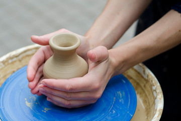 Street master class on modeling of clay on a potter's wheel In the pottery workshop