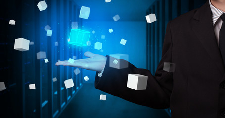 Person holding hologram projection displaying white cubes in server room
