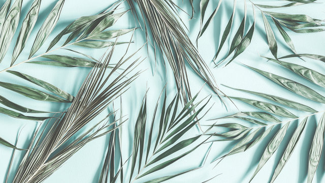 Green palm leaves on pastel mint background. Flat lay, top view, copy space
