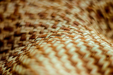 Weaving straws texture. Woven hat with pattern and texture. Close-up abstract background