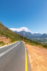 Scenic road at Franschhoek valley with its famous wineries and surrounding mountains, South Africa
