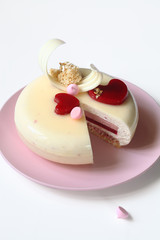 Contemporary Layered Yogurt Mousse Cake decorated with Strawberry Jelly Hearts, on white background.
