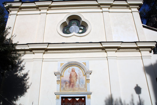 Facciata di chiesa con affresco e finestra a rosone