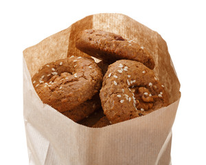 Oatmeal cookies in a paper bag made from kraft paper. Isolated on white background.