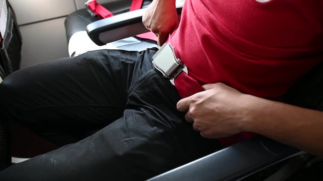 4K Close up hand of asian man fasten seatbelt on the airplane.