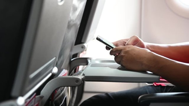 4K Hand of asian man use phone on the airplane.