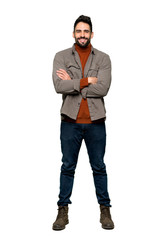 Naklejka premium Full-length shot of Handsome man with beard keeping the arms crossed in frontal position on isolated white background