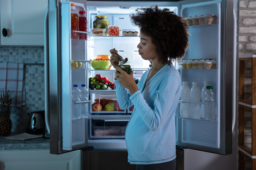 Pregnant Woman Eating Pickle From Jar