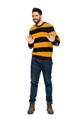 Fototapeta premium Full-length shot of Handsome man with striped sweater smiling on isolated white background