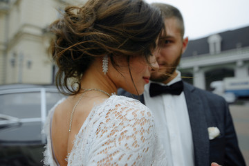 Naklejka premium beautiful gorgeous bride and stylish handsome groom, rustic couple in a sunflower field kissing