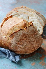 Fresh homemade bread on a gray-blue background, on whole wheat flour. French bread round shape. Bread baking. Unleavened bread