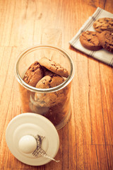 home made chocolate chips cookies biscuits in a glass jar in rustic style 