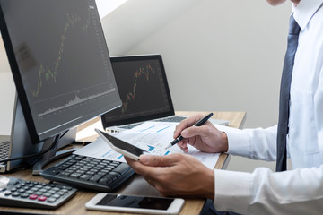 Stock exchange market concept, stock broker looking at graph working and analyzing with display screen, pointing on the data presented and deal on a exchange, Businessman trading stocks online